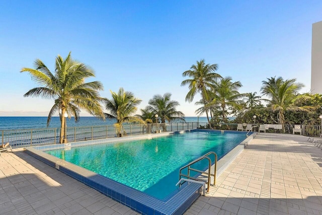 view of pool with a water view and a patio area