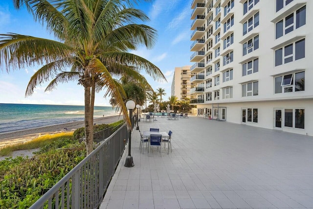 view of property's community with a view of the beach, a patio, and a water view