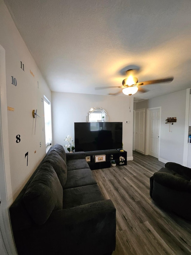 living room featuring ceiling fan, hardwood / wood-style floors, and a textured ceiling