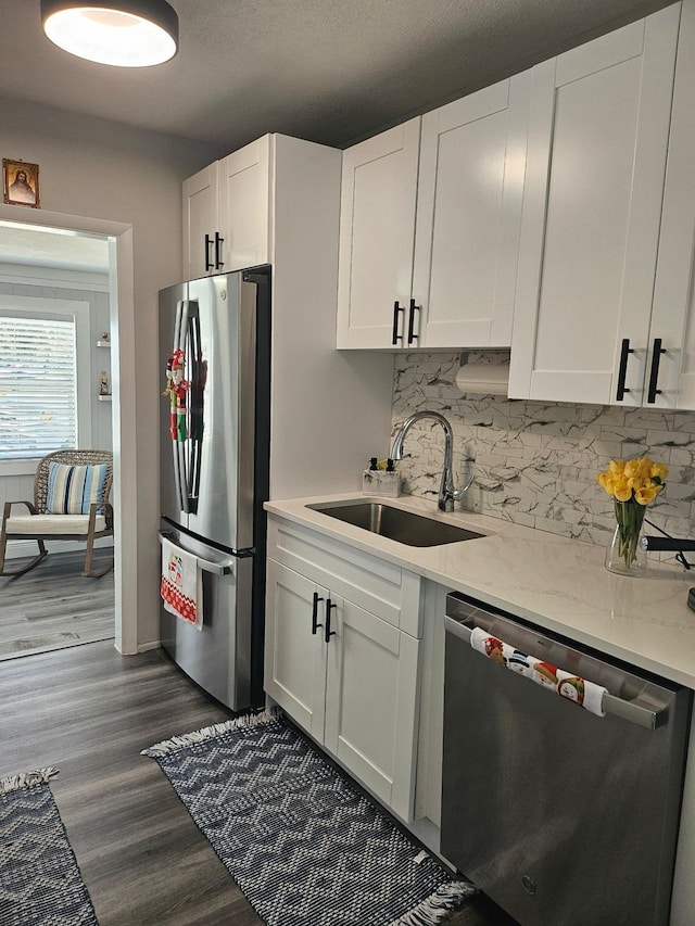 kitchen featuring sink, white cabinetry, tasteful backsplash, appliances with stainless steel finishes, and dark hardwood / wood-style flooring