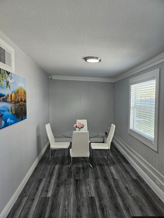 dining space featuring dark hardwood / wood-style floors and a textured ceiling