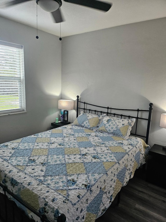 bedroom with dark hardwood / wood-style floors and ceiling fan