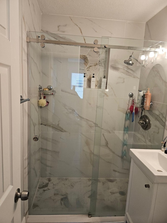 bathroom featuring vanity, a textured ceiling, and walk in shower