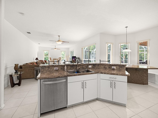 kitchen featuring sink, a kitchen island with sink, white cabinets, decorative light fixtures, and stainless steel dishwasher