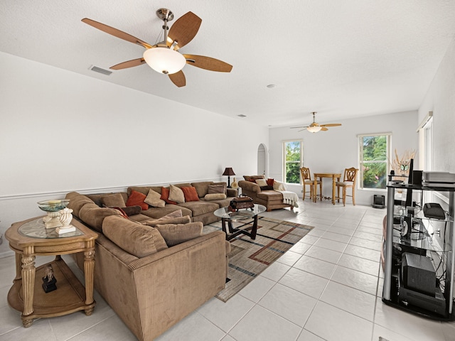 living room featuring light tile patterned floors, a textured ceiling, and ceiling fan