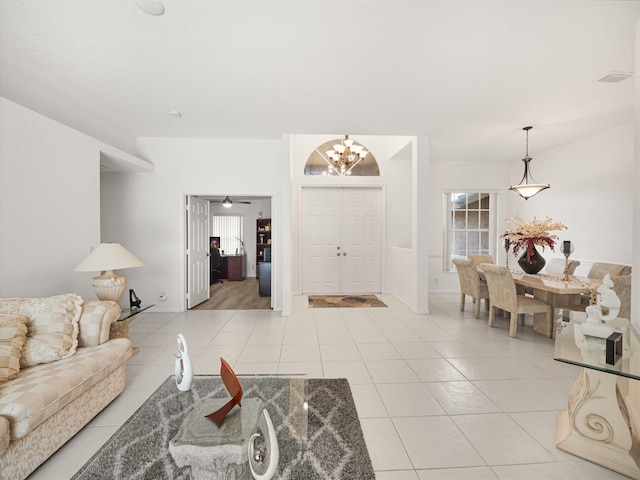 tiled living room featuring a notable chandelier