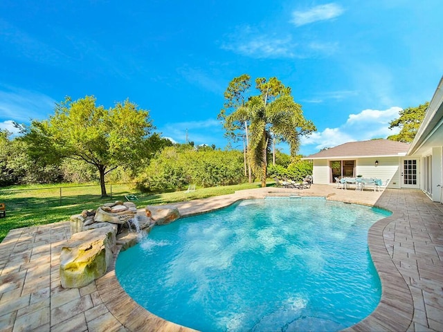 view of swimming pool featuring pool water feature, a yard, and a patio