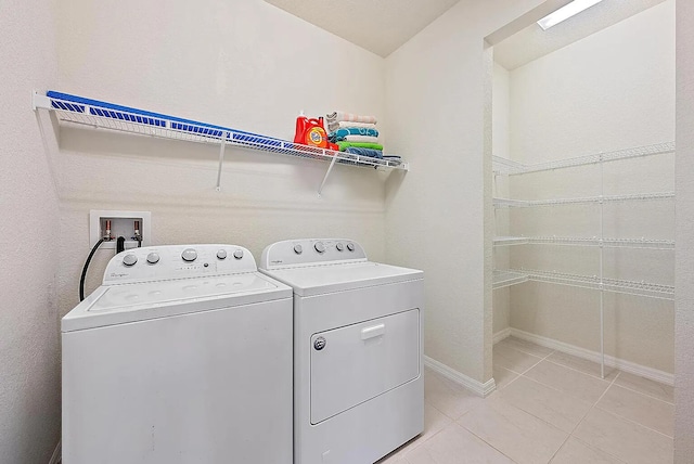 washroom with light tile patterned floors and washing machine and clothes dryer