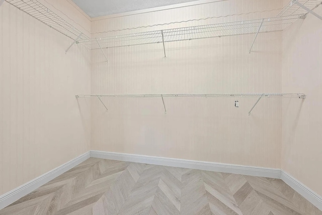 spacious closet with parquet flooring