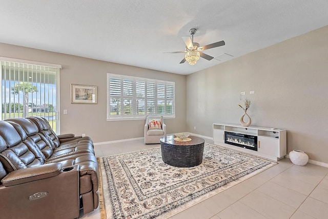 living room with light tile patterned floors, a textured ceiling, and ceiling fan