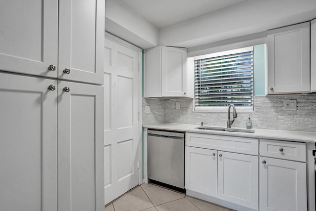 kitchen featuring a sink, dishwasher, light tile patterned floors, white cabinets, and light countertops