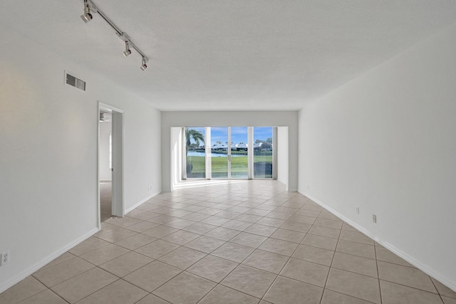 empty room with light tile patterned flooring and baseboards