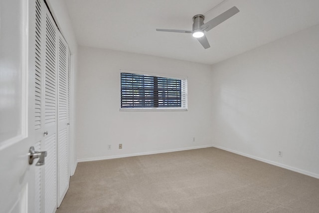 unfurnished bedroom with light carpet, a closet, baseboards, and ceiling fan