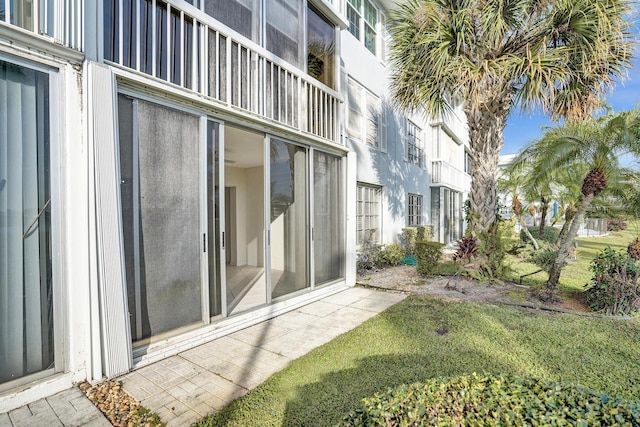 view of exterior entry with a yard