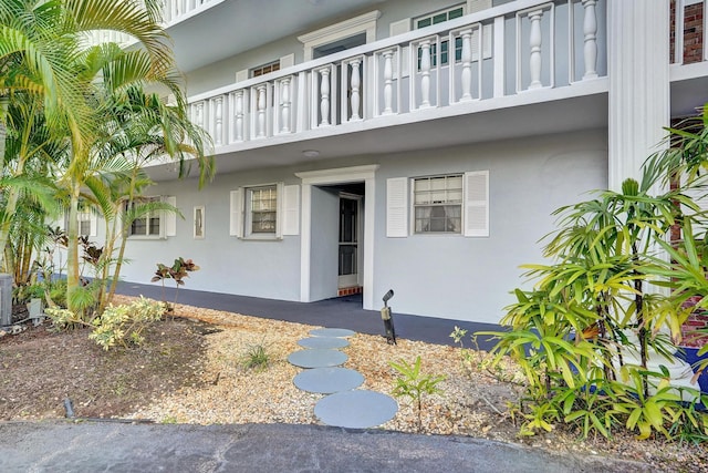 doorway to property featuring a balcony and stucco siding