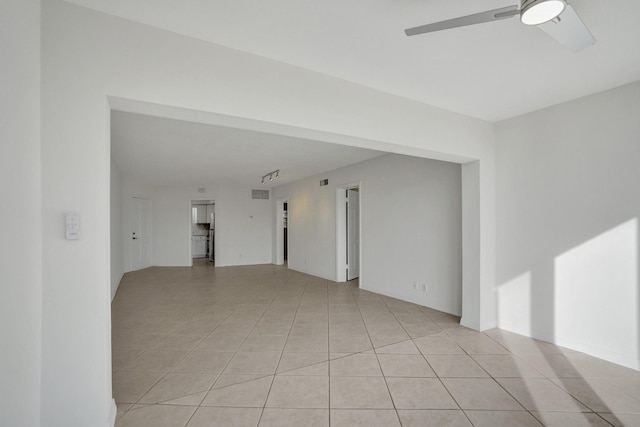 empty room with a ceiling fan and light tile patterned floors