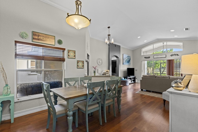 dining space featuring crown molding, lofted ceiling, dark hardwood / wood-style floors, and a notable chandelier