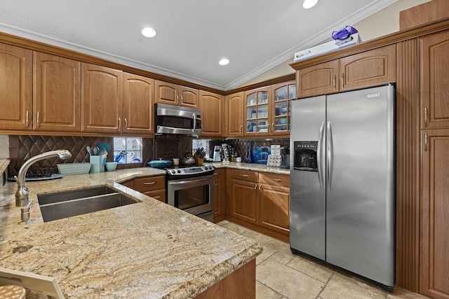 kitchen with lofted ceiling, sink, kitchen peninsula, stainless steel appliances, and crown molding