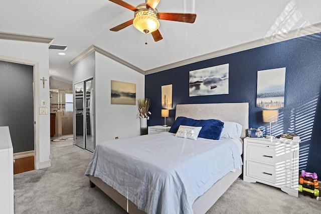 carpeted bedroom with connected bathroom, lofted ceiling, ornamental molding, ceiling fan, and a closet