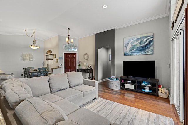 living room featuring hardwood / wood-style flooring, crown molding, and a chandelier