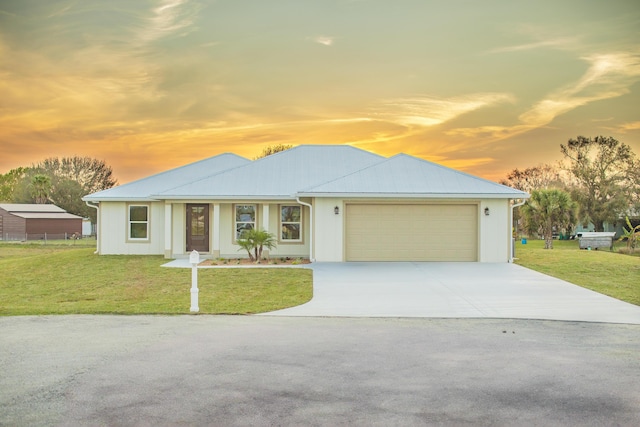 view of front of home featuring a garage and a lawn