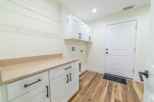 laundry area with cabinets, hookup for an electric dryer, hookup for a washing machine, and light hardwood / wood-style flooring