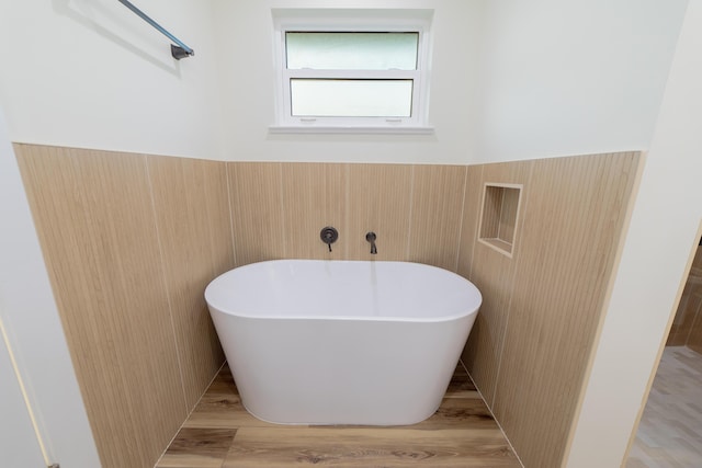 bathroom with hardwood / wood-style flooring and a bathing tub