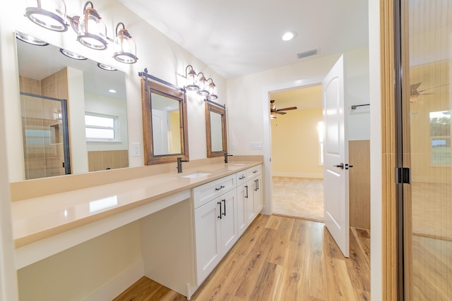 bathroom featuring hardwood / wood-style flooring, vanity, an enclosed shower, and ceiling fan