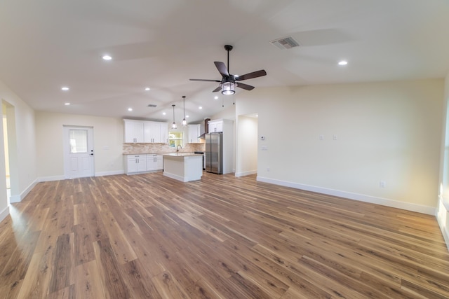 unfurnished living room featuring vaulted ceiling, ceiling fan, and dark hardwood / wood-style flooring