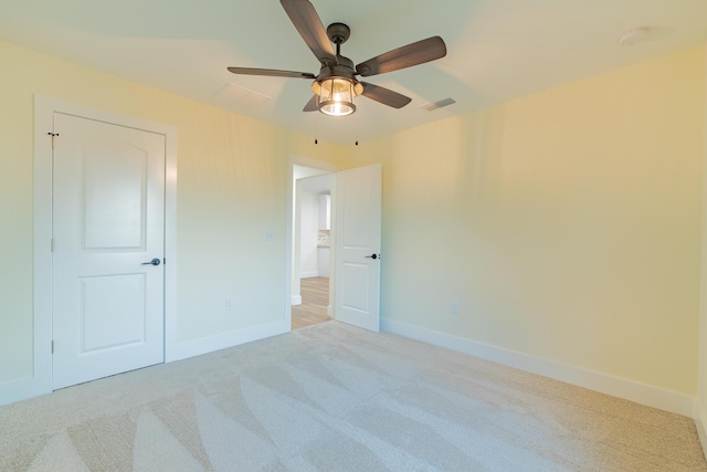 unfurnished bedroom with ceiling fan and light colored carpet