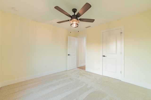 spare room featuring ceiling fan and light colored carpet