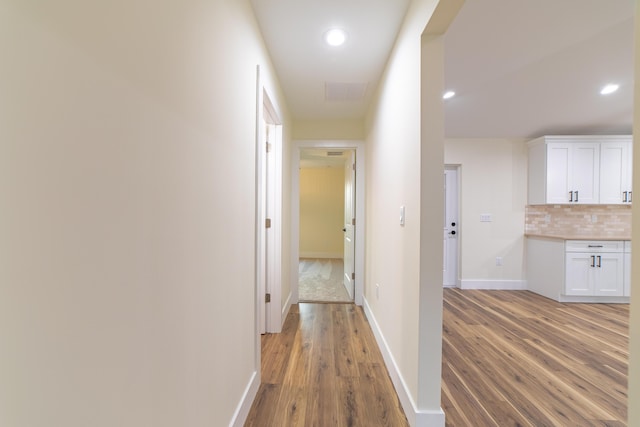 corridor with hardwood / wood-style floors