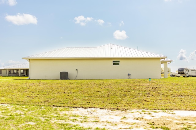 view of side of home featuring a lawn and central air condition unit