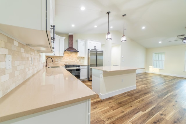 kitchen featuring premium range hood, white cabinetry, sink, a center island, and stainless steel appliances