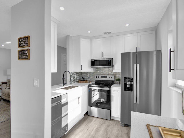 kitchen with tasteful backsplash, stainless steel appliances, and white cabinets