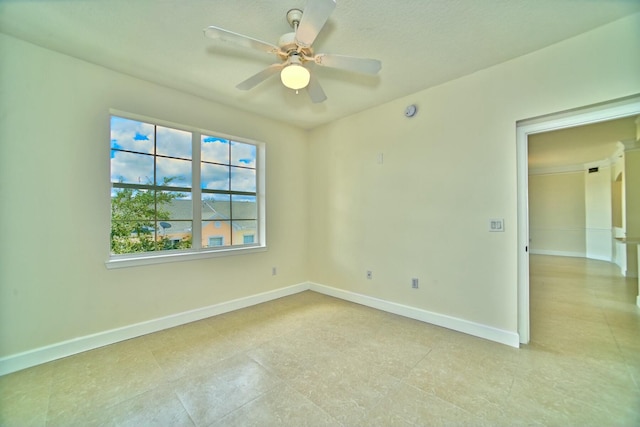 spare room with baseboards and a ceiling fan