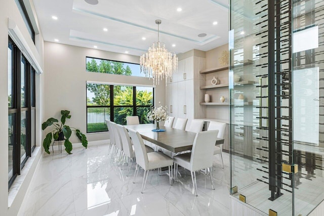 dining room featuring a towering ceiling, a tray ceiling, and a notable chandelier