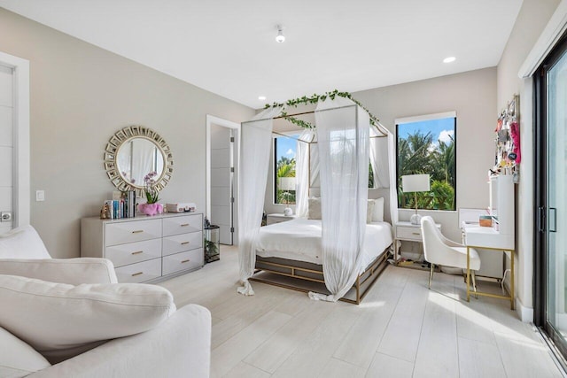 bedroom with multiple windows and light hardwood / wood-style flooring