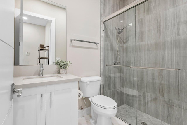 bathroom with vanity, toilet, and a shower with shower door