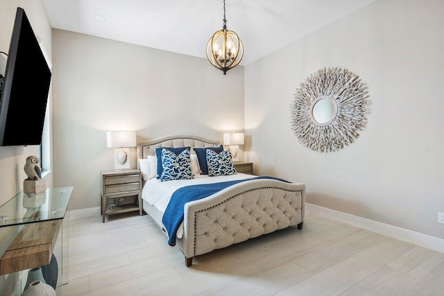 bedroom featuring a notable chandelier and light wood-type flooring