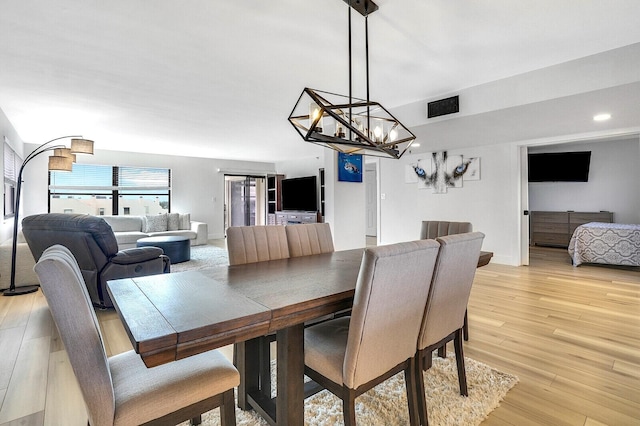 dining room with a chandelier and light wood-type flooring