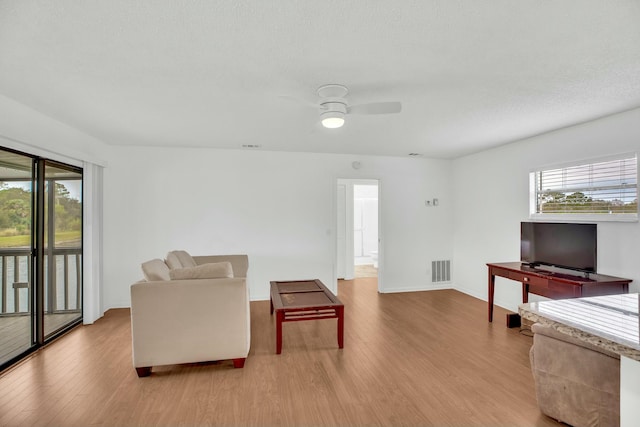 living room with ceiling fan, plenty of natural light, a textured ceiling, and light hardwood / wood-style floors