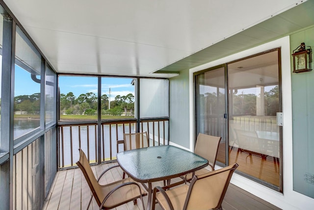 sunroom featuring a water view