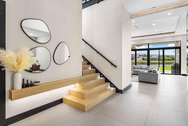 staircase with tile patterned flooring and a high ceiling