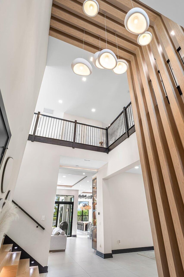 staircase featuring beam ceiling and a high ceiling