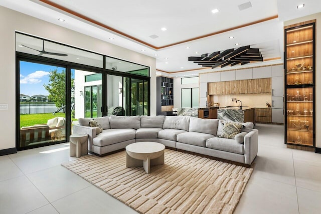 tiled living room with a raised ceiling and sink