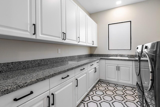 washroom with independent washer and dryer, sink, and cabinets