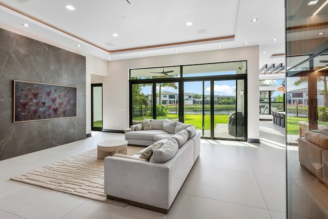 living room featuring light tile patterned flooring, a towering ceiling, and a tray ceiling