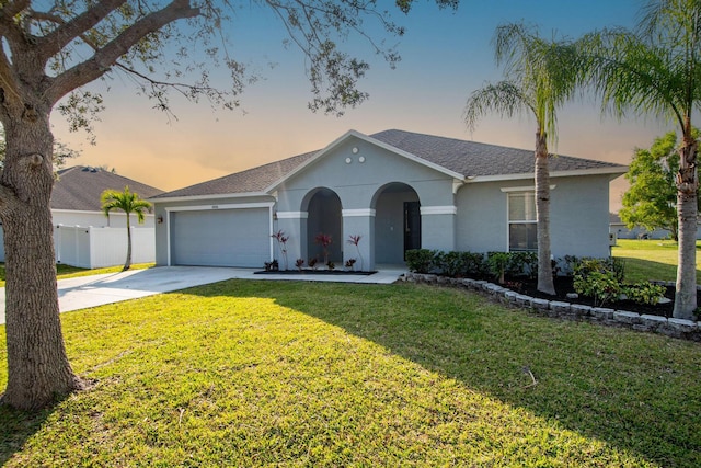 ranch-style home featuring a garage and a lawn