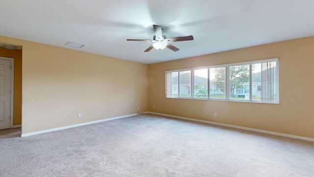 carpeted spare room with ceiling fan with notable chandelier